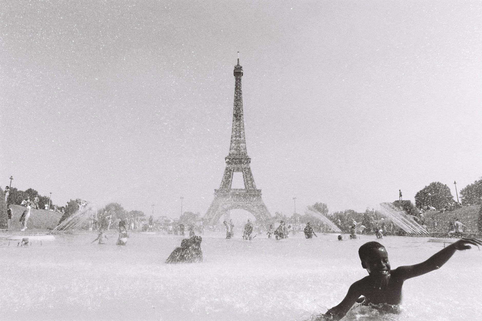 people swimming in fountain near eiffel tower